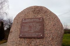 Duży kamień, do którego przytwierdzona jest tablica pamiątkowa.
